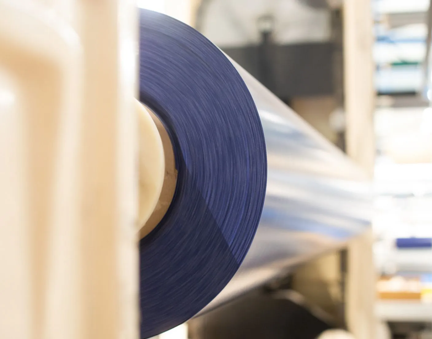 COVERSEAL-entreprise-3 Bobine de film plastique bleu enroulée sur un support dans un environnement industriel lumineux.
