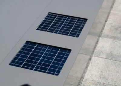 Deux panneaux solaires intégrés dans une surface grise, entourés de dalles en pierre claire.