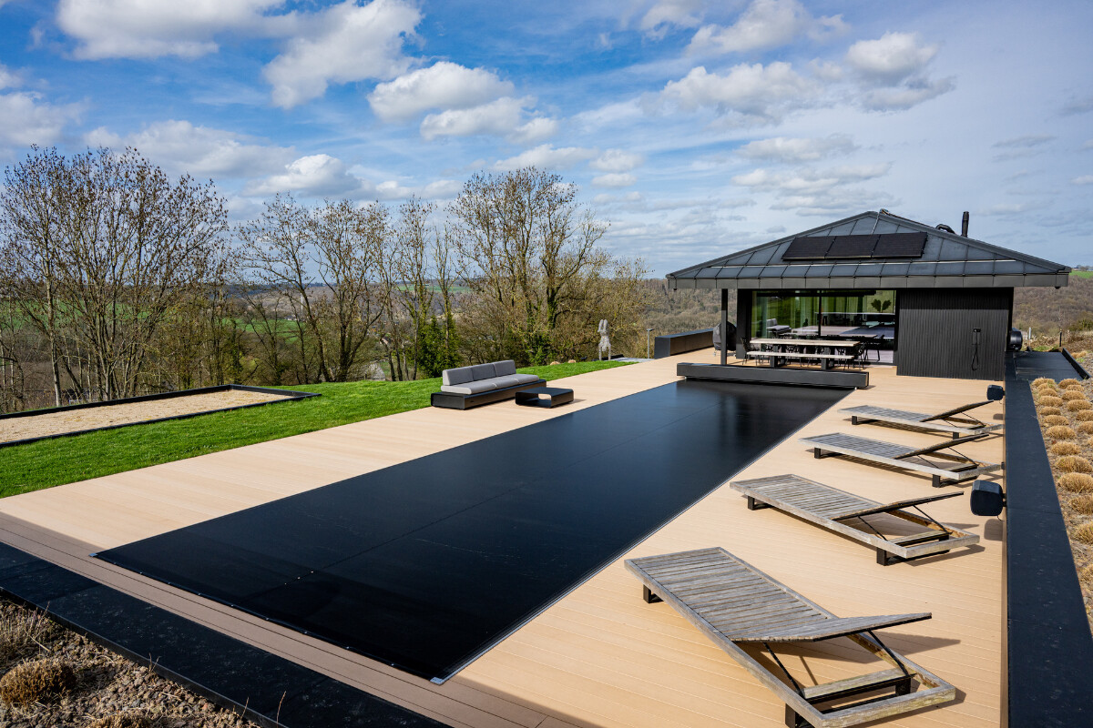 Gros plan sur l’escalier immergé et la couverture Coverseal fermée partiellement, reflétant la lumière sur l’eau turquoise.