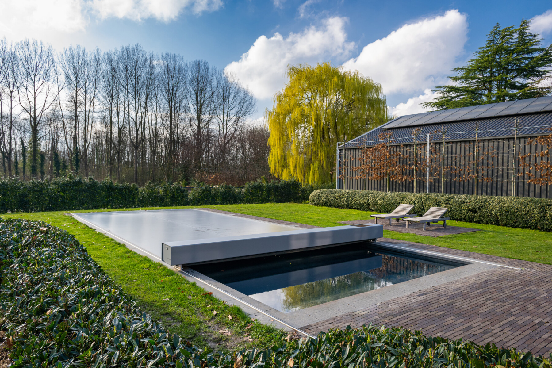 Gros plan sur l’escalier immergé et la couverture Coverseal fermée partiellement, reflétant la lumière sur l’eau turquoise.